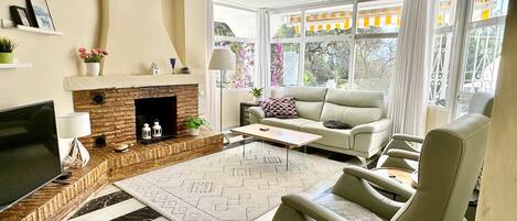 A living room with a fireplace, a sofa, a coffee table, and a TV.