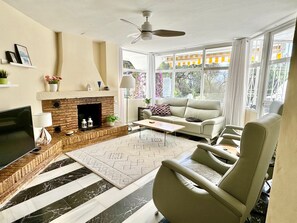 A living room with a fireplace, a sofa, a coffee table, and a TV.