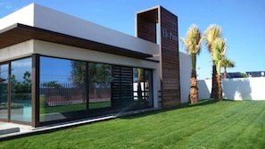 A modern building with large glass windows, a wooden facade, and a sign that reads "Els Pines."
