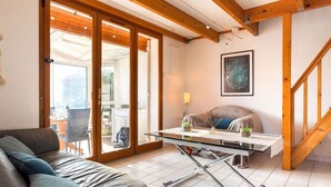 A modern living room with a sofa, a glass-top coffee table, and a staircase. - Cosy apartment for 4 guests with WIFI, TV and terrace (Narbonne)