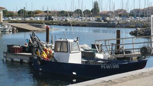 A marina with several boats docked, including a blue boat with the registration number PV 401 006. - Cosy apartment for 4 guests with WIFI, TV and terrace (Narbonne)
