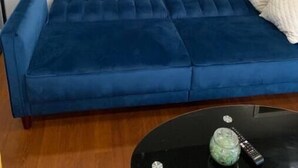 A blue sofa against a white wall with two landscape paintings. - Cozy, Convenient, Modern update (Gonzales)
