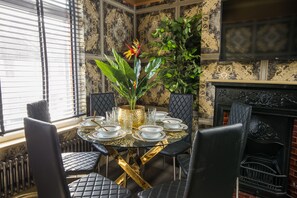 A dining area with a round table set for six, surrounded by black upholstered chairs. - Luxury Versace 1 Bed, Hot Tub, Pool Table, Sky Tv (Greater London)