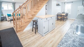 Une cuisine moderne avec des meubles en bois, un plan de travail en granit et une cuisinière encastrée.