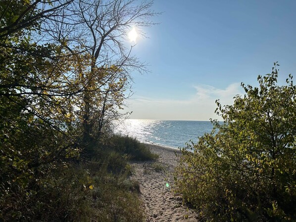 Ranta lähistöllä, aurinkotuoleja, rantapyyhkeitä