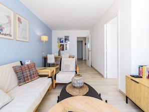 Ein modernes Wohnzimmer mit einer Couch, einem Couchtisch und einem Essbereich mit Stühlen.