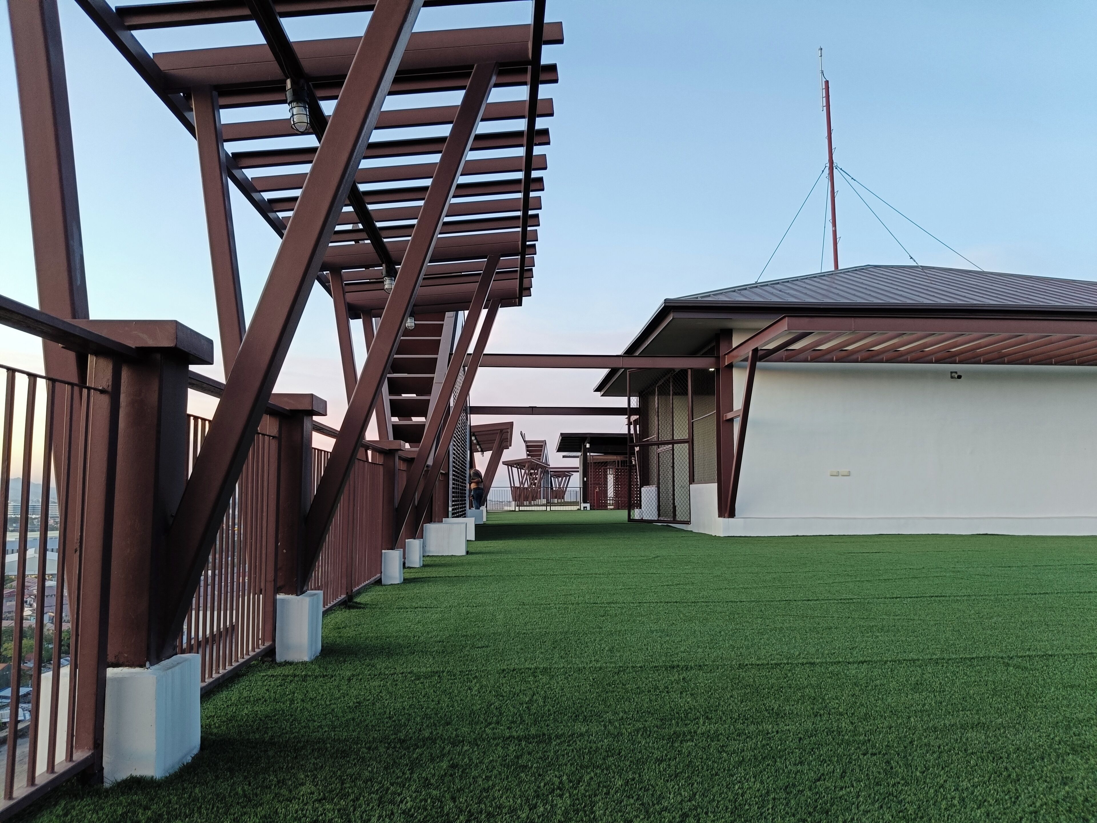 A pathway with artificial grass leading to a building with a sloped roof.