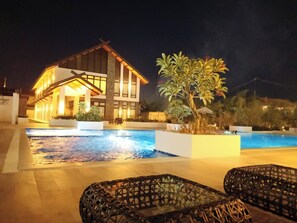 Um hotel moderno com piscina, área de estar ao ar livre e ambiente bem iluminado.