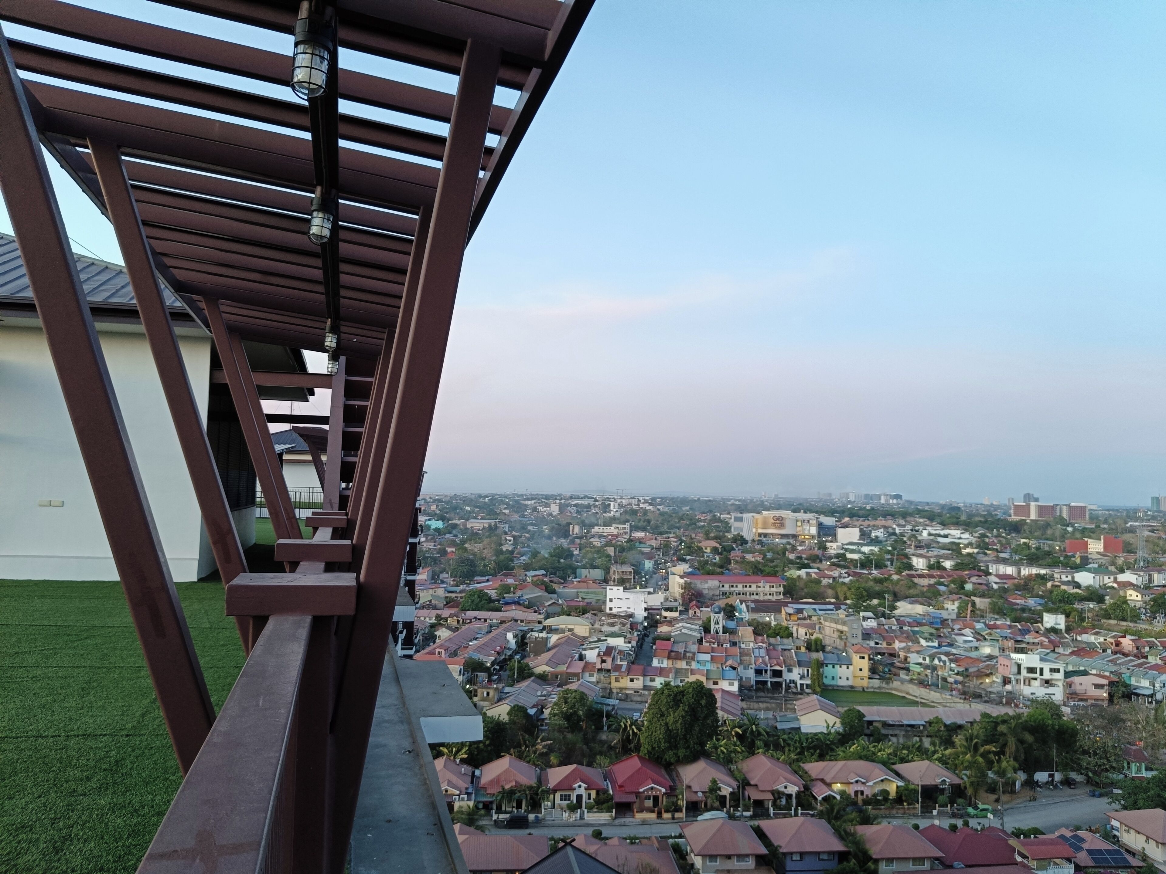 A residential area with a view of a cityscape, including various buildings and a clear sky.