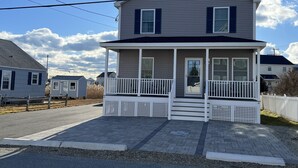 A two-story house with a front porch and a small attached garage. - Unwind Oceanside
Private single family home (Hampton)