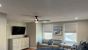 A bedroom with a bed, a dresser, a desk, a ceiling fan, and two windows with blinds. - Unwind Oceanside
Private single family home (Hampton)