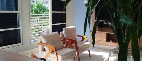 Una habitación con un sofá, una mesa y una planta en maceta.