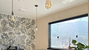 A modern kitchen with a marble countertop, a knife, a plate with pastries, and a potted plant. - CoVívere - RJ (Rio de Janeiro)