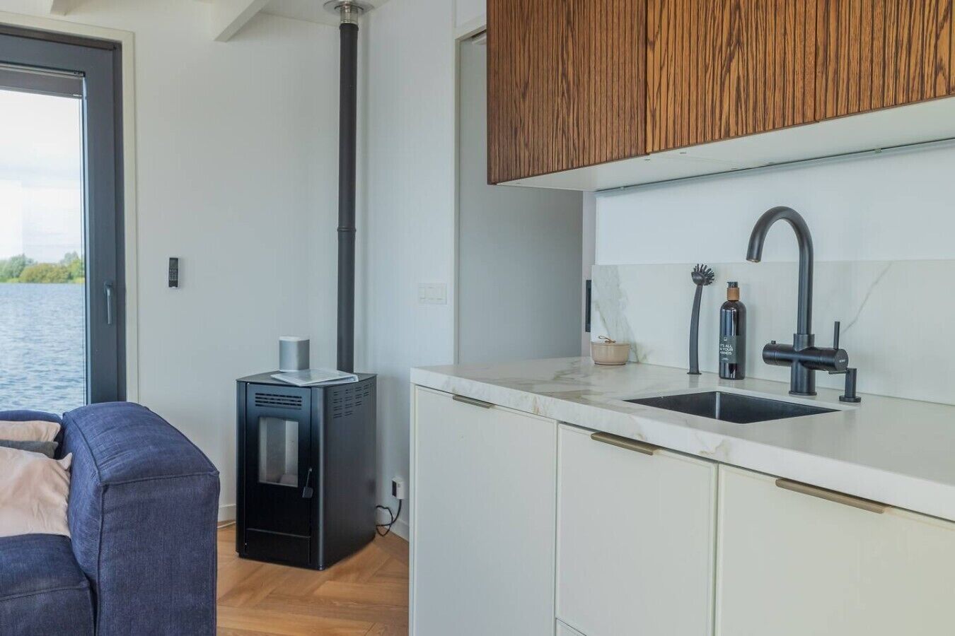 Eine moderne Küche mit eingebautem Herd, einer Spüle mit einem modernen Wasserhahn und Holzschränken.