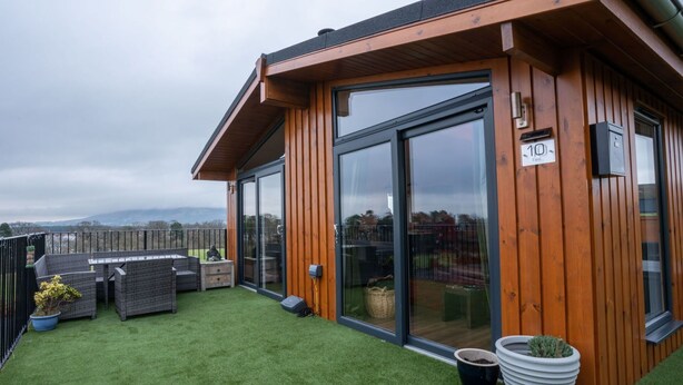 Een modern gebouw met een houten gevel en grote glazen deuren.