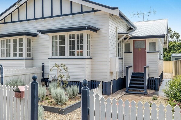 A two-story house with a front porch, a mailbox, and a small garden. - "Camellia Cottage"! CDB Diamond! (Toowoomba City)