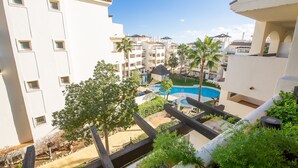 A resort with a swimming pool, multiple balconies, and lush greenery. - Residencial Duquesa 12 39 2b (Manilva)
