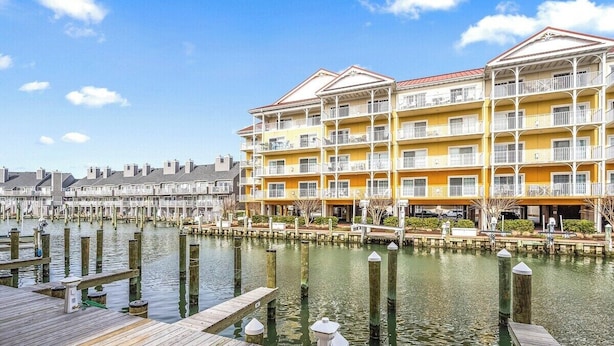 A waterfront hotel with multiple balconies and a dock extending into the water. - Canalfront 2 Bedroom-Sleeps 6-Laundry-WiFi (Ocean City)