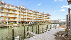 A waterfront hotel with multiple balconies, a dock, and a marina. - Canalfront 2 Bedroom-Sleeps 6-Laundry-WiFi (Ocean City)