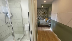 Um banheiro com box de vidro, pia branca e vaso sanitário.