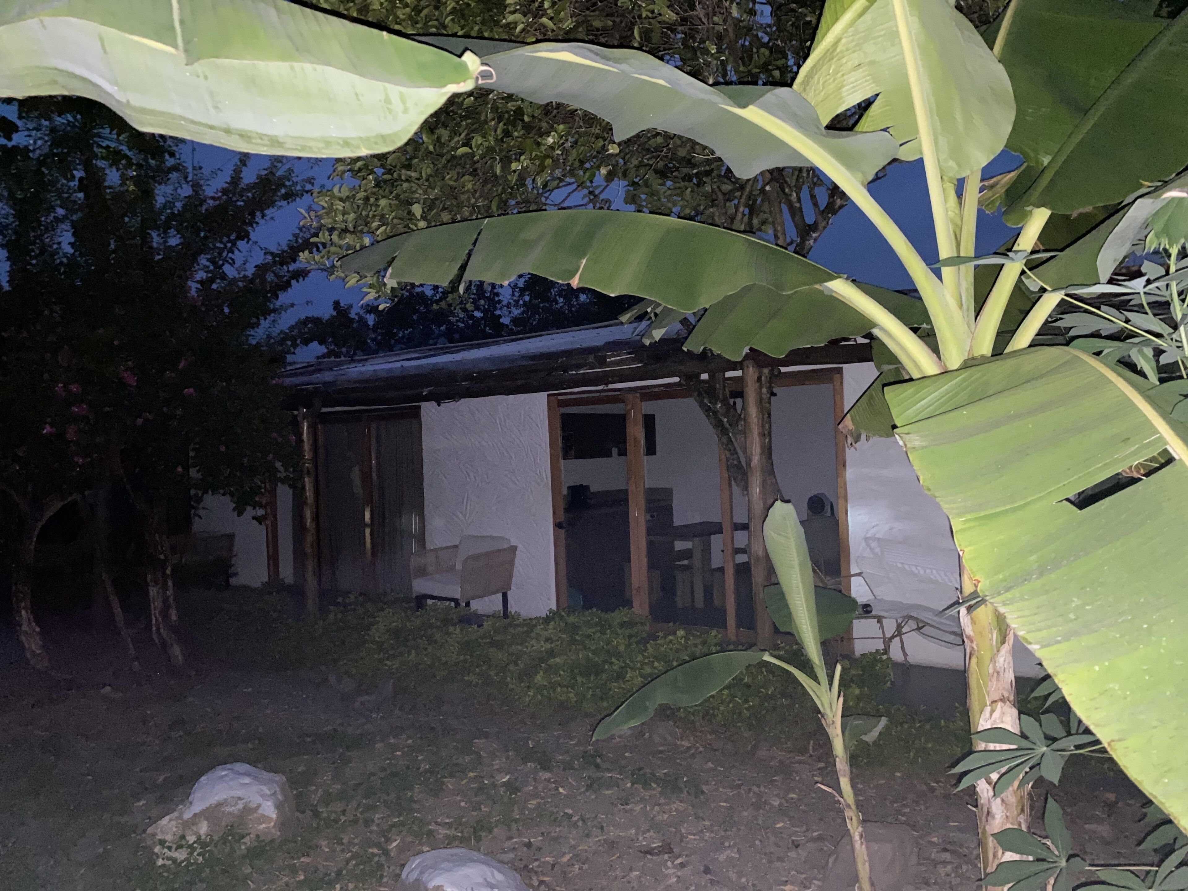 A small, single-story building with a porch and a chair outside.