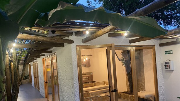 Eine Spa-Suite mit Glastür, Holzboden und einer kleinen Sitzecke.