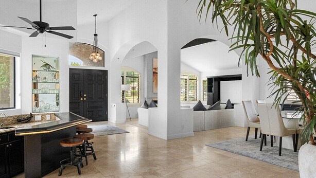 A spacious kitchen with a central island, bar stools, and a ceiling fan. - Whispering Wells - Private Pool (Indian Wells)