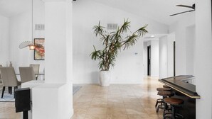 A modern kitchen with a central island, bar stools, and a potted plant. - Whispering Wells - Private Pool (Indian Wells)