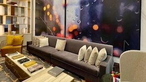 Una sala de estar moderna con un sofá modular, una mesa de centro y una estantería.