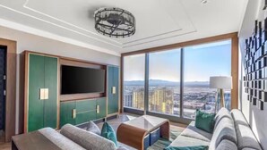 A modern living room with a large flat-screen TV, comfortable seating, and a city view through large windows. - Las Vegas | Modern City Retreat | Pool + Gym (Las Vegas)