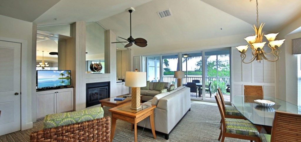 A spacious living area with a fireplace, a dining table with chairs, and a view of the outdoors.