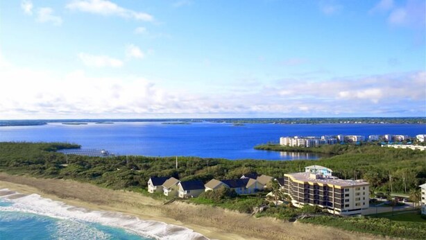 A coastal hotel with multiple buildings, a beach, and a view of the ocean.
