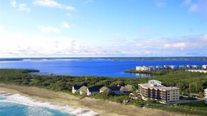 A coastal hotel with multiple buildings, a beach, and a view of the ocean.