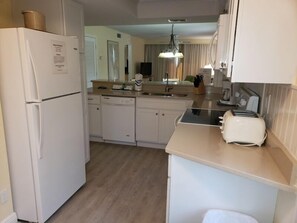 Eine kleine Küche mit Kühlschrank, Geschirrspüler und Toaster.