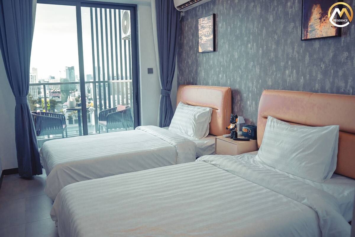 Habitación de hotel con dos camas, vistas a la ciudad y un diseño moderno.