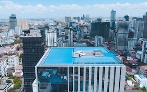 A high-rise building with a rooftop pool, surrounded by other buildings. - Phnom Penh Pool Hotel 24 USD M Residence (Phnom Penh)