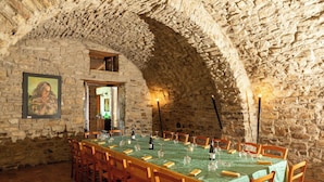 A dining room with a long table set for a meal, stone walls, and a framed painting on the wall. - Beautiful private villa with WIFI, private pool, TV, terrace, pets allowed and panoramic view (Trivigno)