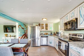 Una cocina equipada con refrigerador, lavavajillas, estufa y microondas.