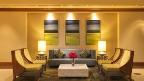A lobby with a sofa, two armchairs, a coffee table, and three wall-mounted lamps. - Orlando | Easy Disney Retreat | Pool + Parks (Orlando)
