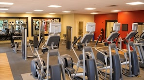 A gym with various exercise equipment, including treadmills and weight machines. - Orlando | Luxury Disney Retreat | Pool + Parks (Orlando)
