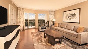 A modern living room with a sofa, coffee table, and a TV on a black stand.