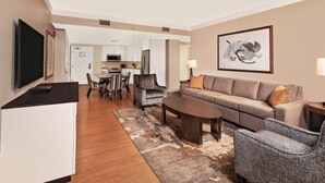 A modern hotel room with a dining area, a sofa, a coffee table, and a TV. - Orlando | Family Resort Retreat | Pool + Parks | 2BR (Orlando)