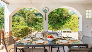 An outdoor dining area with a table set for six, surrounded by chairs, and a view of greenery. - Wonderful private villa for 8 people with private pool, A/C, WIFI, TV and pets allowed (Vidreres)