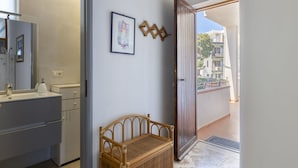 Baño con lavabo, espejo y una silla de mimbre.