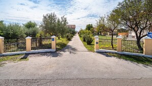 A gated entrance to a property with a clear pathway leading to a building.