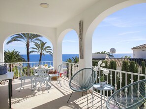 Enjoy a serene sea view from this balcony with comfortable seating and a beautiful view.