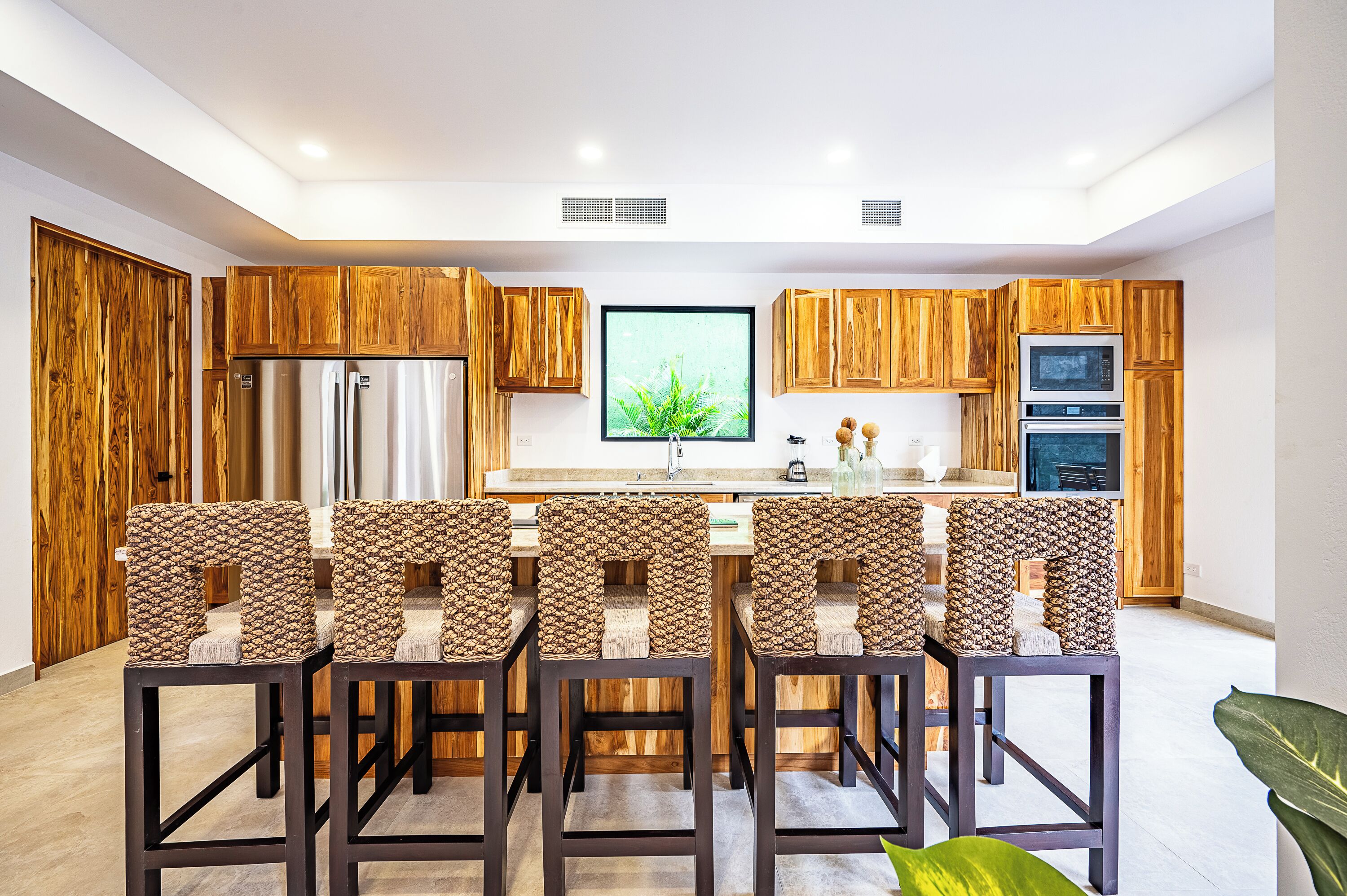 Une cuisine moderne avec des meubles en bois, un grand îlot central et un téléviseur à écran plat.