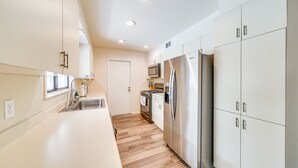 A modern kitchen with white cabinets, stainless steel appliances, and a wooden floor. - Pet-Friendly San Antonio Vacation Rental w/ Pool! (San Antonio)