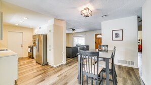 A modern kitchen with a central island, a dining area with a table and chairs, and a living space with a sofa and a TV. - Pet-Friendly San Antonio Vacation Rental w/ Pool! (San Antonio)