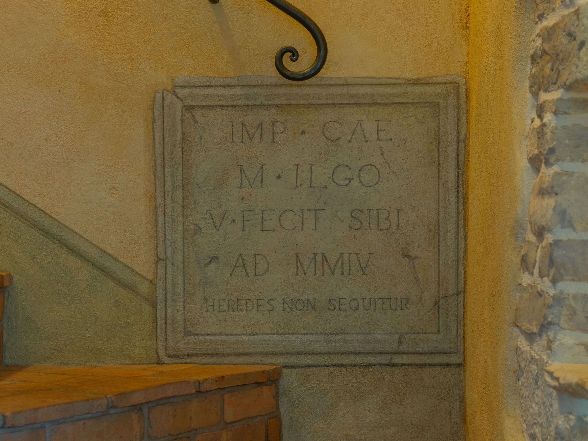 Une plaque de pierre gravée, fixée à un mur.